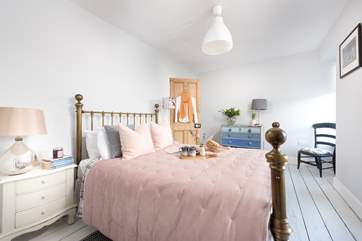 Pretty as a picture, the double bedroom has a dreamy brass bedstead and reclaimed floorboards to add to the charm.