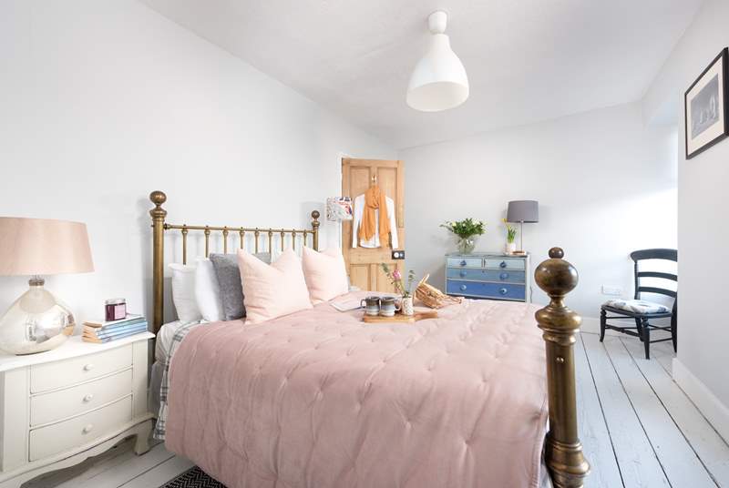 Pretty as a picture, the double bedroom has a dreamy brass bedstead and reclaimed floorboards to add to the charm.