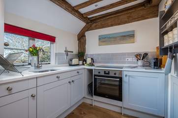 The small but perfectly formed kitchen has characterful exposed beams.