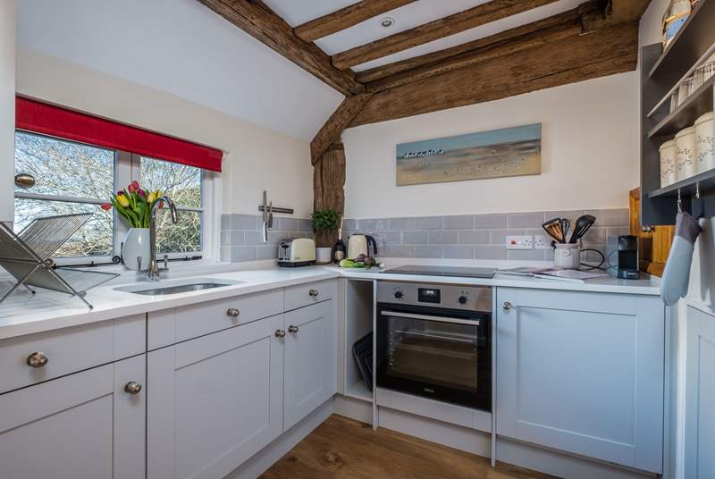 The small but perfectly formed kitchen has characterful exposed beams.