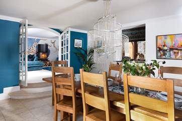 The dining-room with statement light fixture is the ideal place for everyone to gather. Two steps lead into the sitting-room.