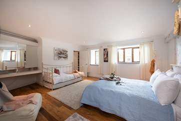 The spacious bedroom comfortably sleeps two adults and a child on the day bed.