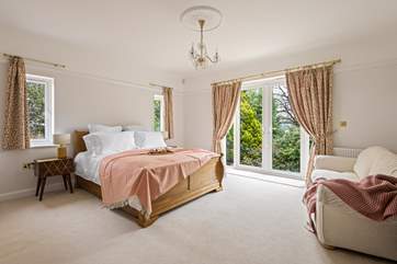 Dreamy bedroom 1 has a sumptuous king-size bed and dual-aspect windows overlooking the garden.