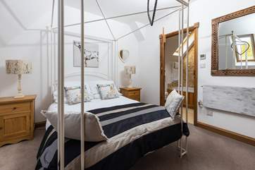 Bedroom Two has a luxurious four-poster bed and crisp white linens, quite the recipe for a restful sleep.