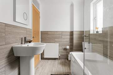 The gorgeous new bathroom has a bath and shower.