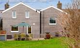 The beautifully clad rear of Happy Place with a gorgeous decked area for al fresco dining. - Thumbnail Image