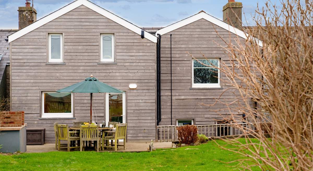 The beautifully clad rear of Happy Place with a gorgeous decked area for al fresco dining.