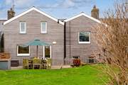 The beautifully clad rear of Happy Place with a gorgeous decked area for al fresco dining.