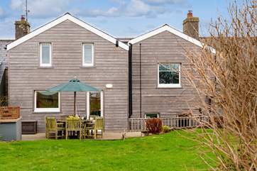 The beautifully clad rear of Happy Place with a gorgeous decked area for al fresco dining.