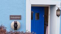 The blue door welcomes you, and there's a handy charging point for your electric car.