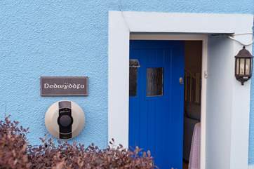 The blue door welcomes you, and there's a handy charging point for your electric car.