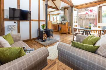 The open plan living space is light, bright and airy; but the comfy furniture and crackling wood-burner ensure that you can happily spend a cosy evening in.