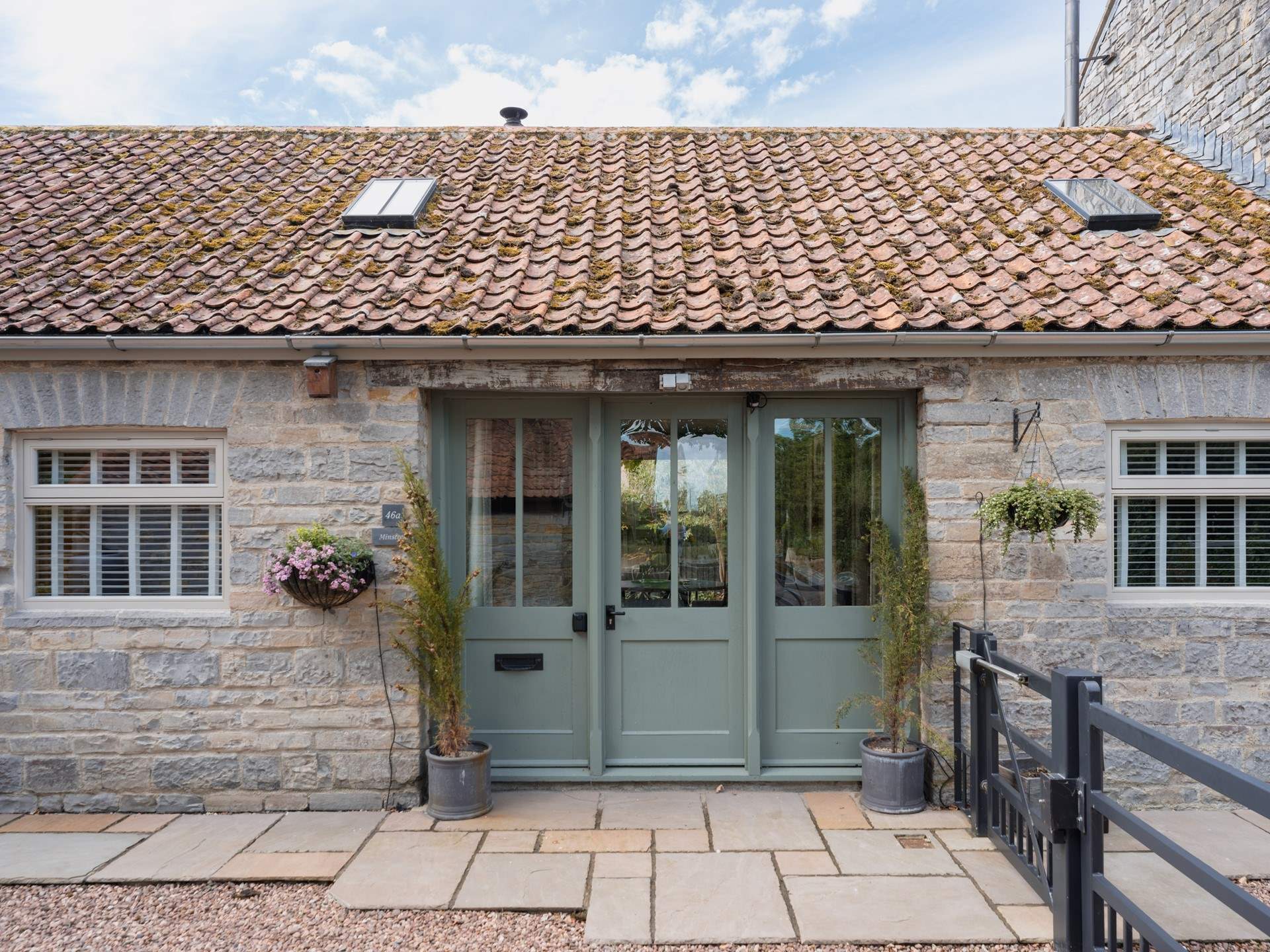 Welcome to Minstrels! With its charming rustic stonework and welcoming frontage. You can see the cream door leading to neighbouring The Smithy on the left.