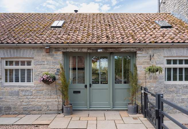 Welcome to Minstrels! With its charming rustic stonework and welcoming frontage. You can see the cream door leading to neighbouring The Smithy on the left.