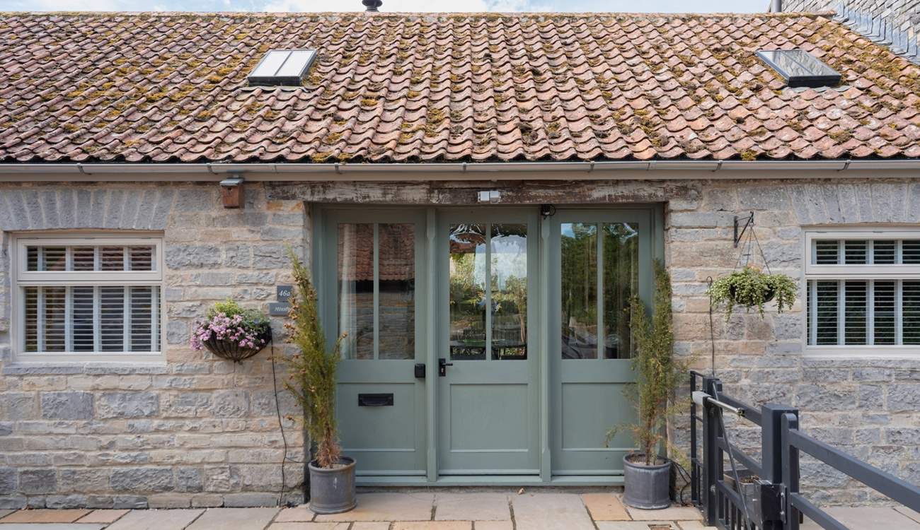 Welcome to Minstrels! With its charming rustic stonework and welcoming frontage. You can see the cream door leading to neighbouring The Smithy on the left.