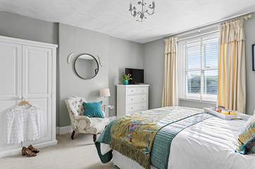 The dreamy double bedroom with a king-size bed is beautifully furnished in soft pastels.