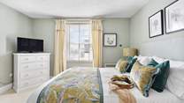 The dreamy double bedroom with a king-size bed is beautifully furnished in soft pastels.