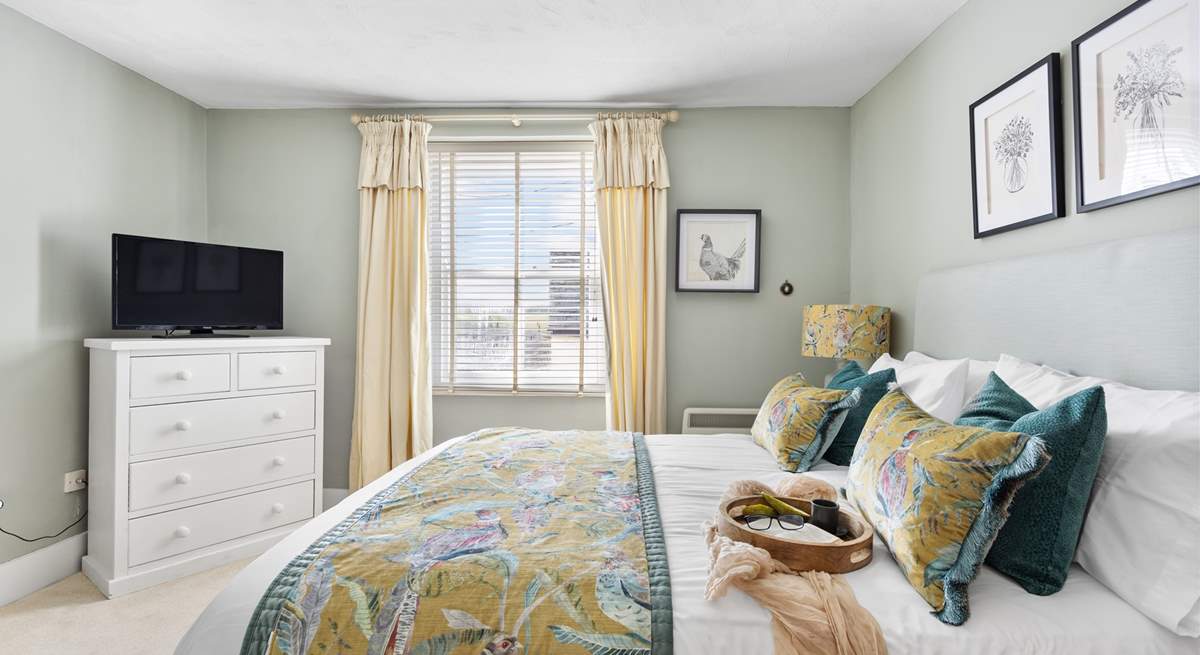 The dreamy double bedroom with a king-size bed is beautifully furnished in soft pastels.