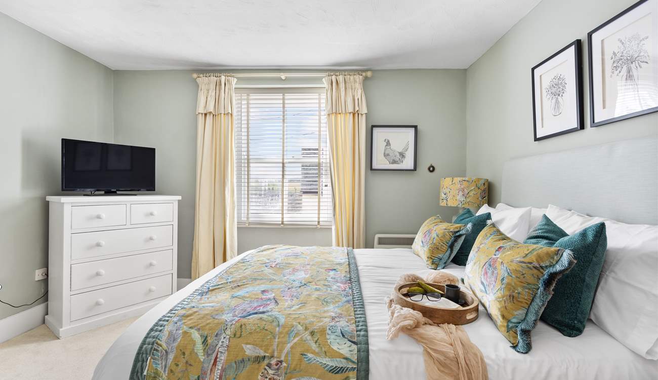 The dreamy double bedroom with a king-size bed is beautifully furnished in soft pastels.