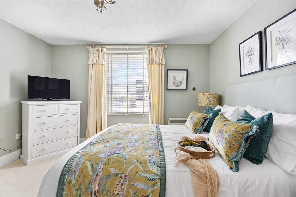 The dreamy double bedroom with a king-size bed is beautifully furnished in soft pastels.