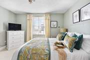 The dreamy double bedroom with a king-size bed is beautifully furnished in soft pastels.