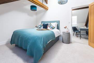 Bedroom 4 with luxury linens and a comfy bed leads off the mezzanine level.