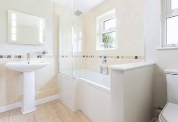 The family bathroom has a bath with rainfall shower over.
