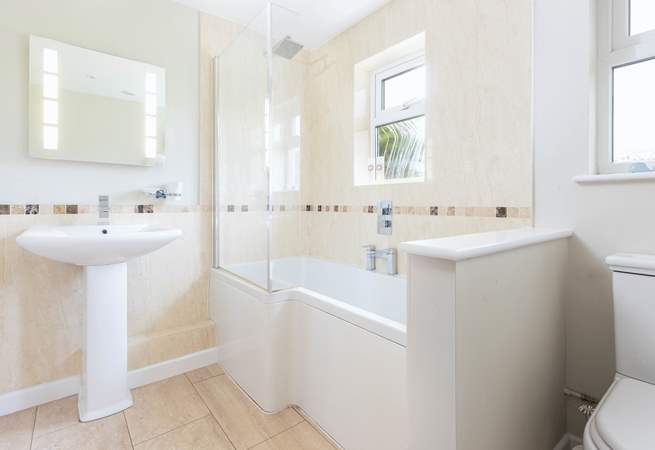 The family bathroom has a bath with rainfall shower over.
