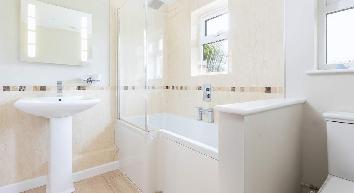 The family bathroom has a bath with rainfall shower over.
