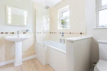 The family bathroom has a bath with rainfall shower over.