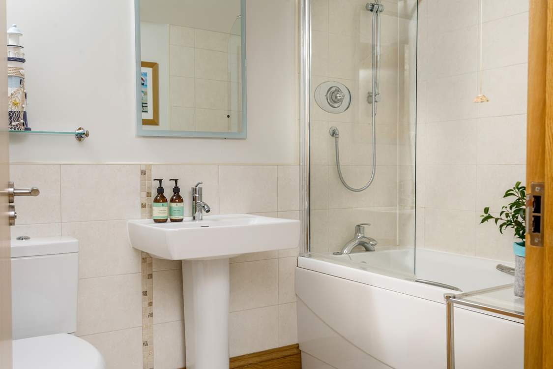 The family bathroom on the ground floor has a bath with shower over.