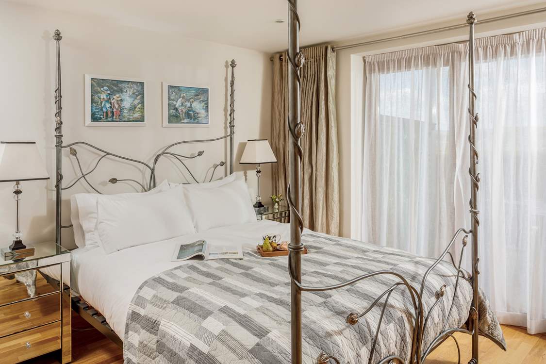 This dreamy bedroom on the ground floor has a stunning bedstead with a super comfy king-size bed.