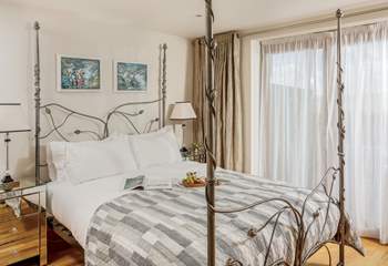 This dreamy bedroom on the ground floor has a stunning bedstead with a super comfy king-size bed.