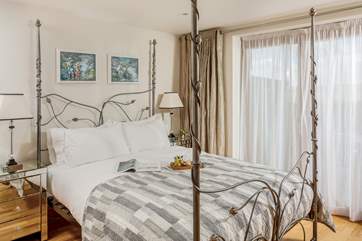 This dreamy bedroom on the ground floor has a stunning bedstead with a super comfy king-size bed.