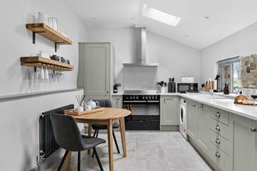 The super sleek kitchen has a sweet table and chairs for two, the perfect place to sit and chat with the chef.