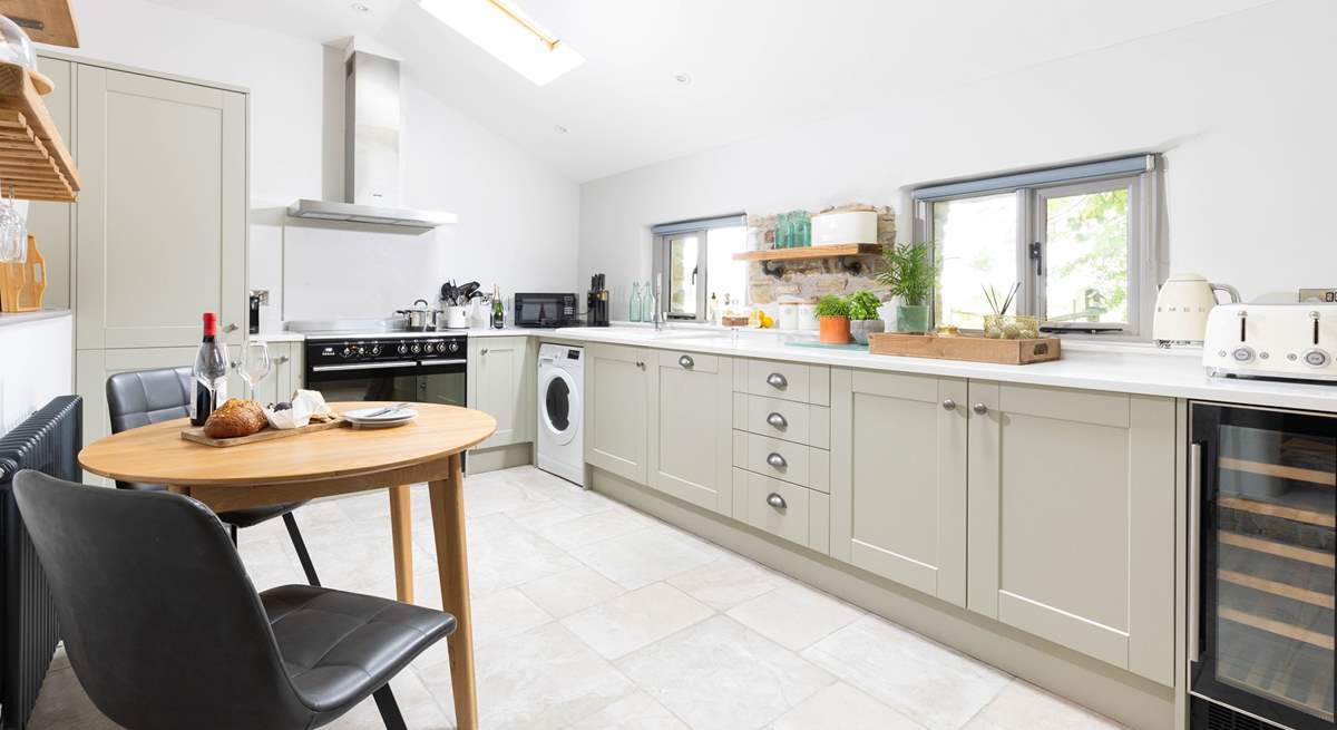 The super sleek kitchen has a sweet table and chairs for two, the perfect place to sit and chat with the chef.