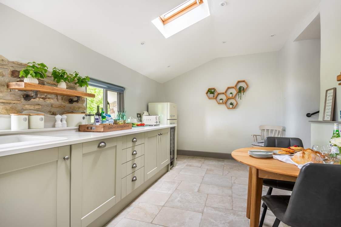 The super sleek kitchen has a sweet table and chairs for two, the perfect place to sit and chat with the chef.