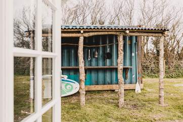 The old shipping container has been cleverly converted to add a shelter, perfect for storing surfboards, bikes and wetsuits. The space also doubles up as a rustic outdoor kitchen.