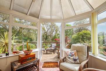 The lovely conservatory looks out onto the tranquil woods and decking area.