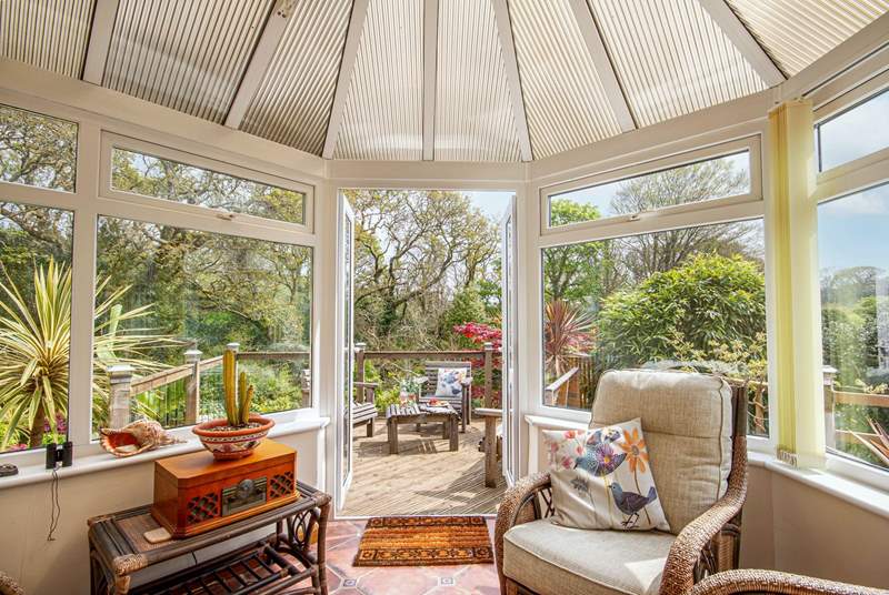 The lovely conservatory looks out onto the tranquil woods and decking area. 