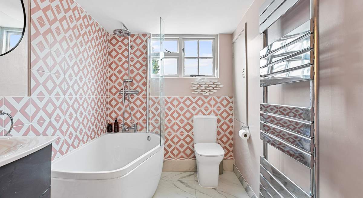 The snazzy first floor bathroom has a bath with rainfall shower over.