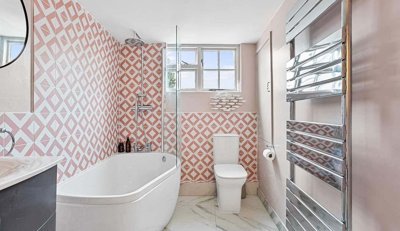The snazzy first floor bathroom has a bath with rainfall shower over.