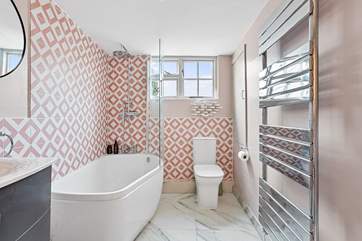 The snazzy first floor bathroom has a bath with rainfall shower over.