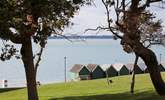 Beach huts stand looking out to see at Gurnard. - Thumbnail Image