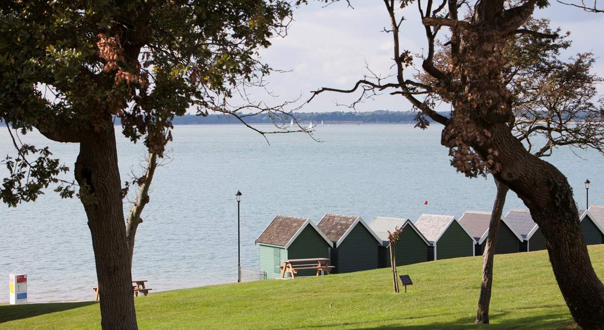 Beach huts stand looking out to see at Gurnard.