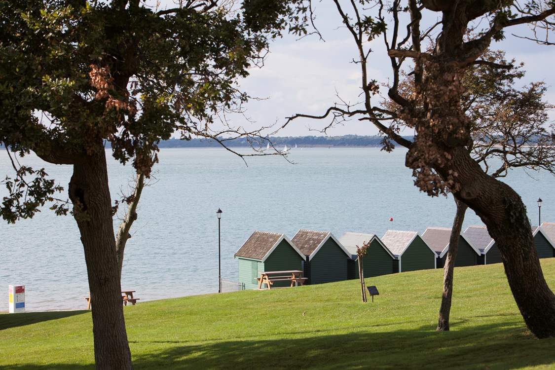 Beach huts stand looking out to see at Gurnard.