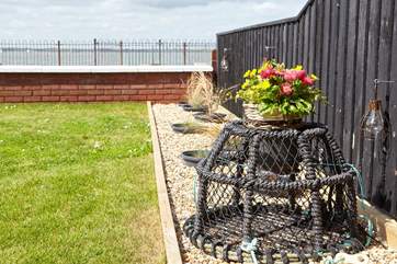 Lobster pot, grasses and lantern lights border the garden at Sea Lights.