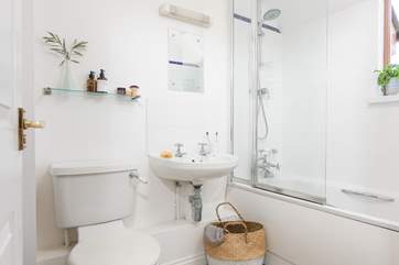 The family bathroom has a bath with shower over.