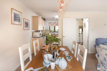 The kitchen is tucked away behind the dining-table.