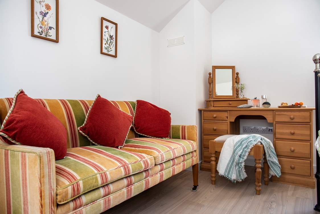Take a moment on the comfy sofa at the end of the bed.